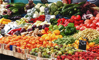 Bild von einem Marktstand mit Gemüse.